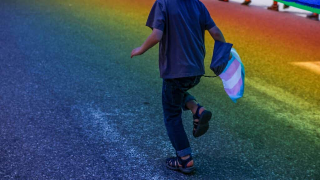 child with rainbow on street